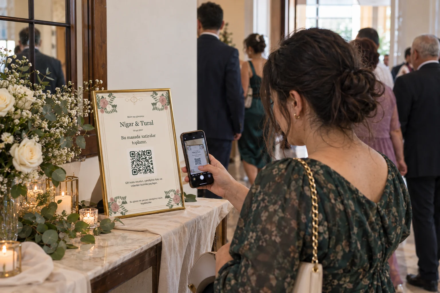 A guest scans Nigar and Tural's floral A4 QR poster in a small frame at the wedding entrance